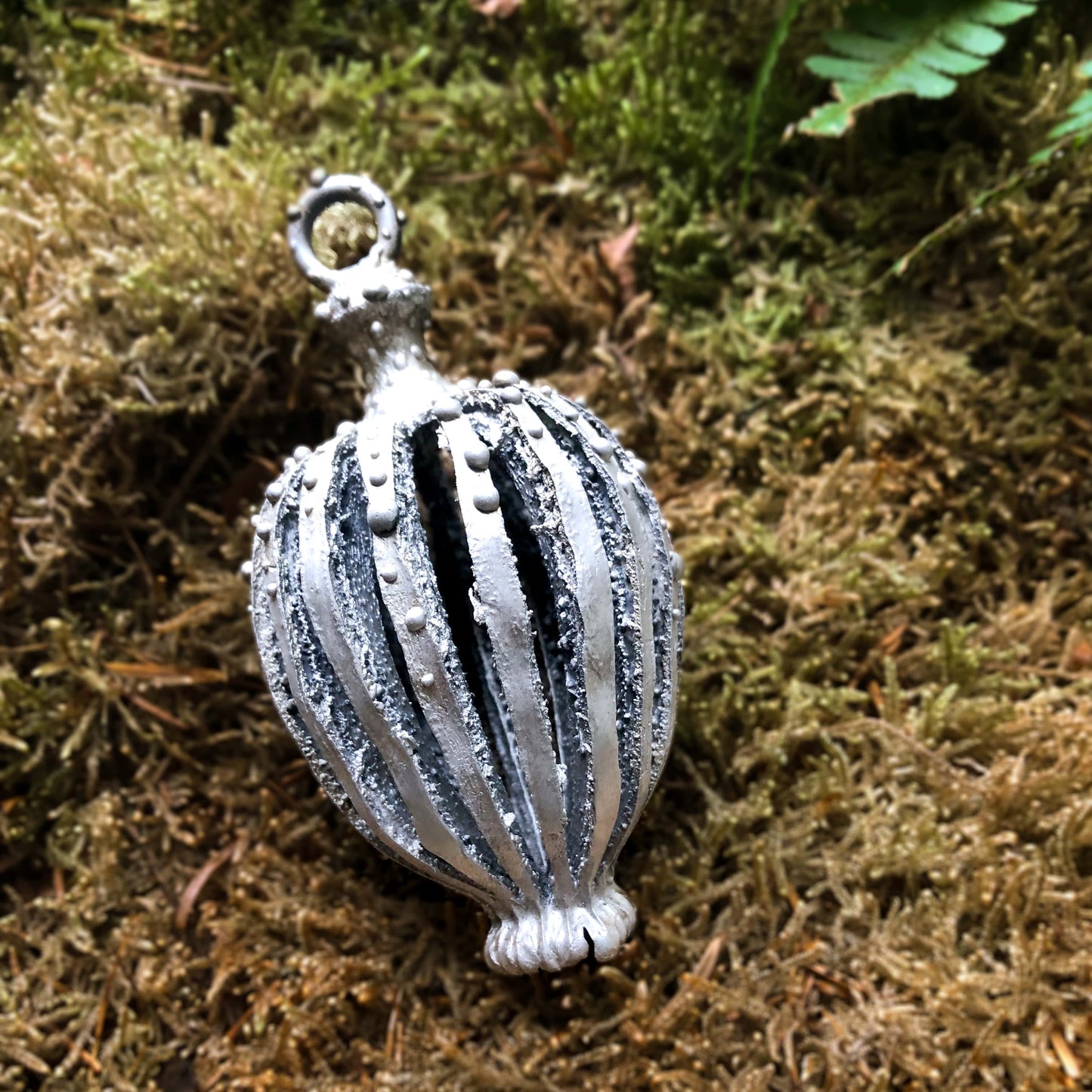 Großer Mohnanhänger aus Silber liegend auf Moos.