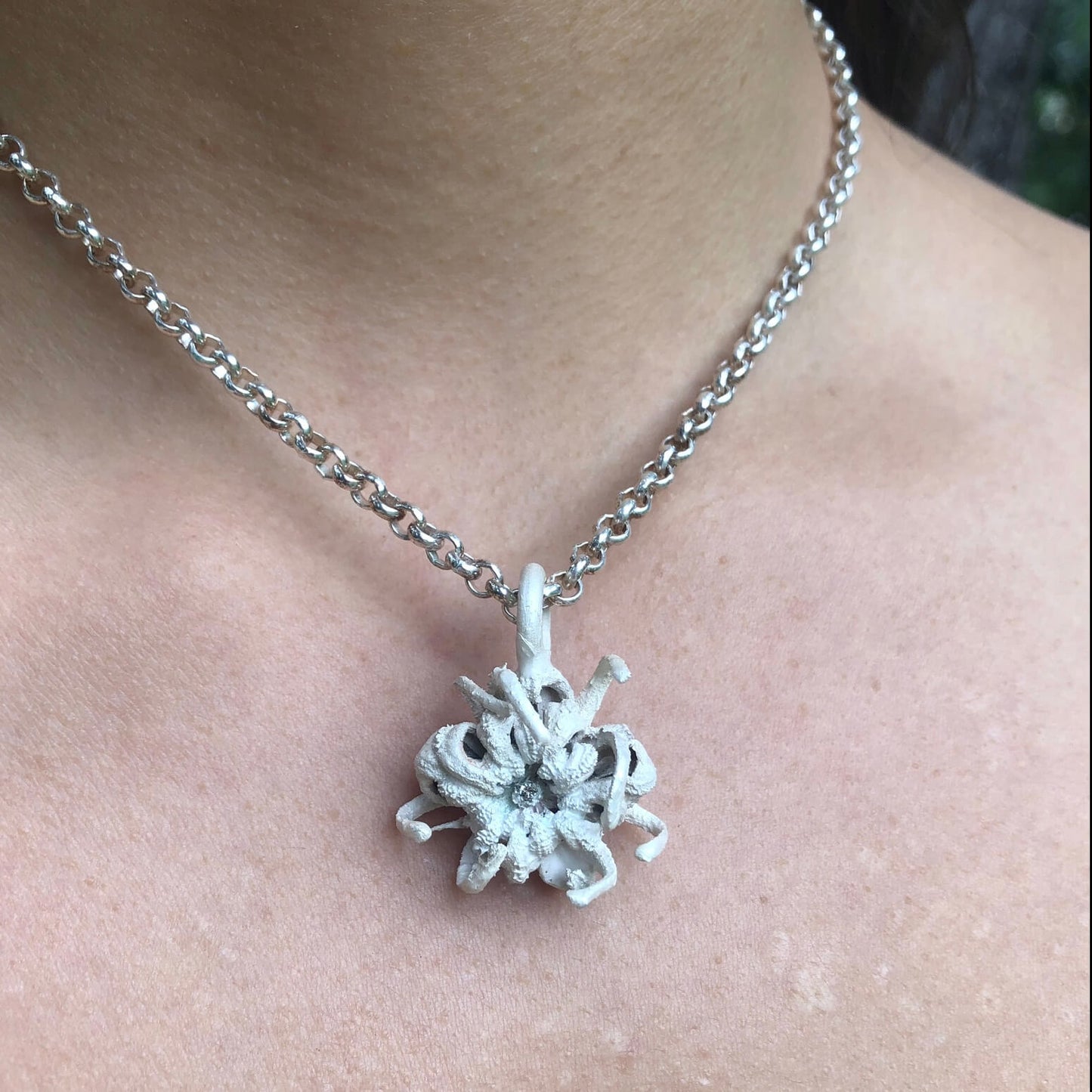 Kettenanhänger Calendula mit Brillant mit einer Silberkette von einem Model getragen.