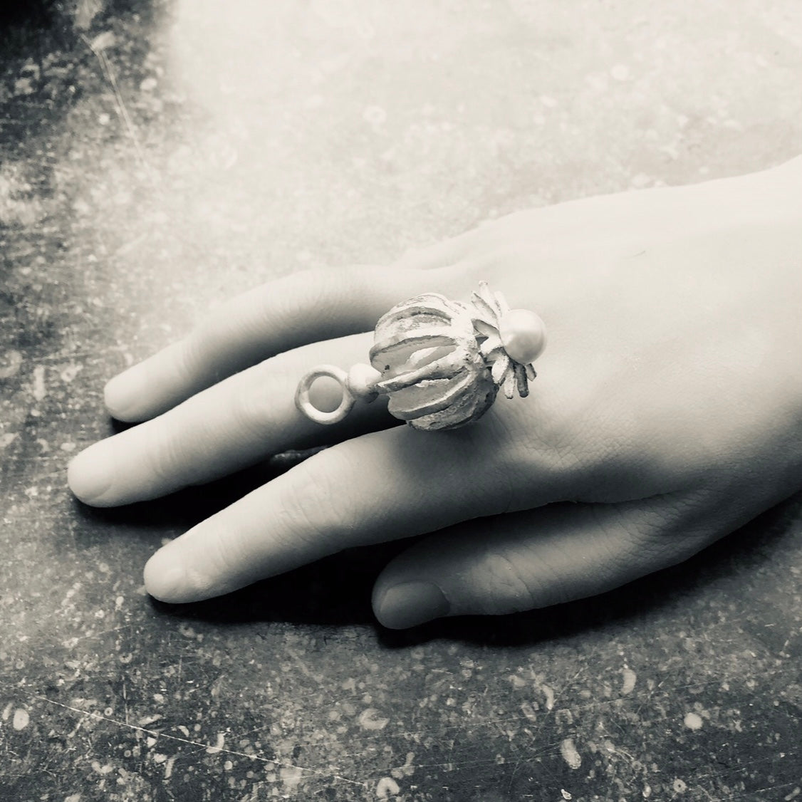 Großer Mohnanhänger liegend auf einer Hand.