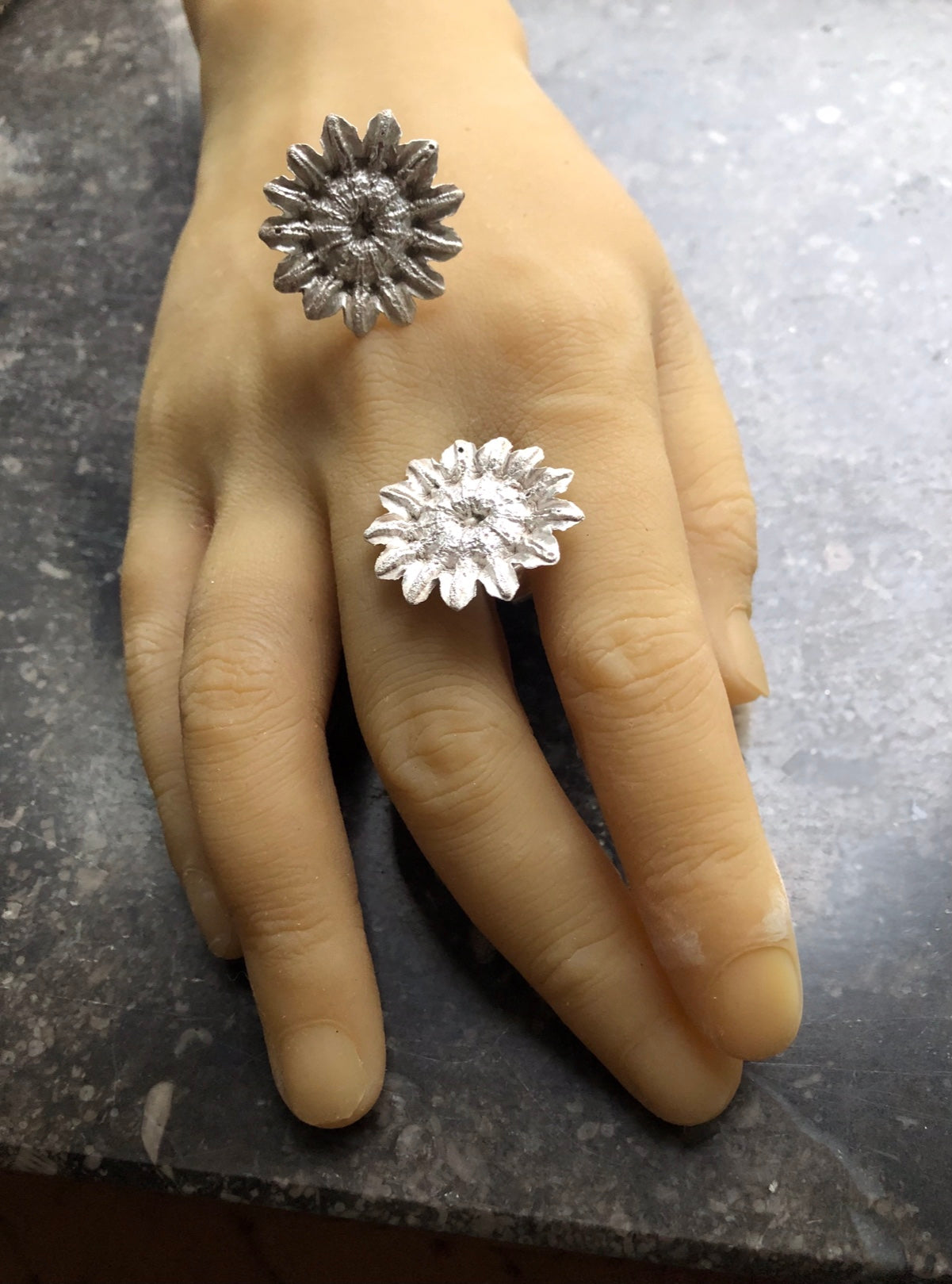 Große Silberohrstecker in Mohnform liegend auf einer Hand