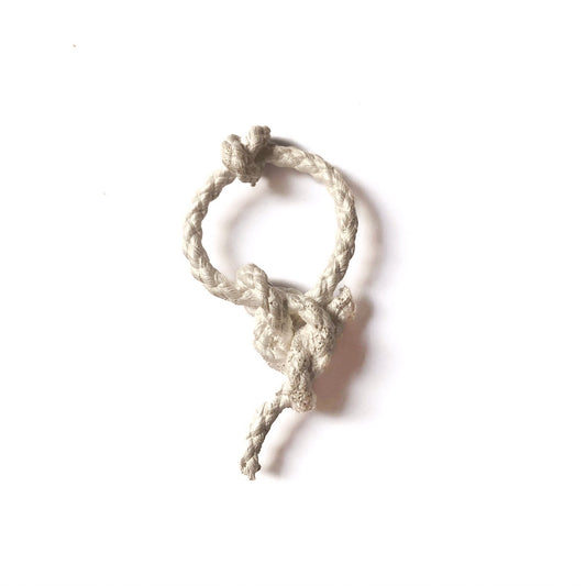 Nahaufnahme eines kunstvoll gefertigten Knoten-Anhängers aus Silber, der die unendliche Verbindung und das ewige Versprechen symbolisiert.