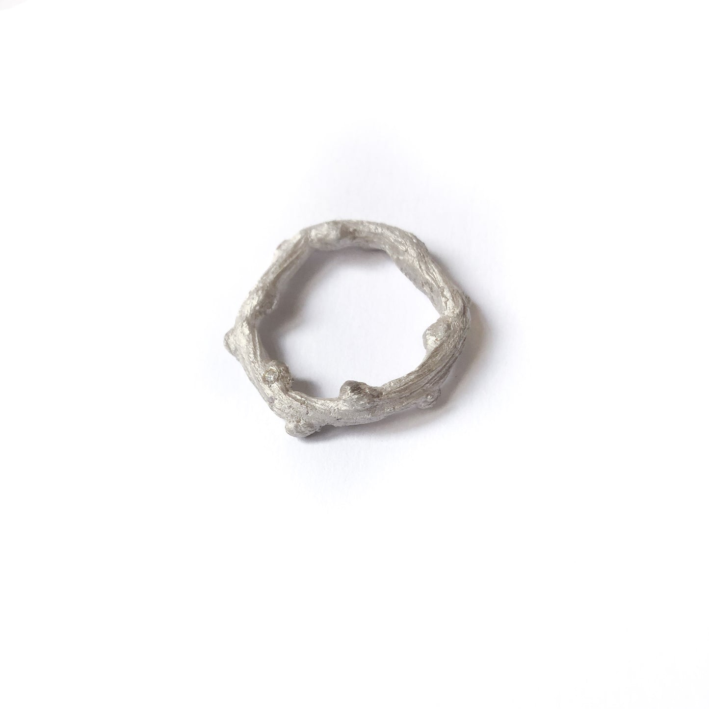 Handgefertigter Astring aus Silber mit drei Brillanten, freigestellt, liegend fotografiert
