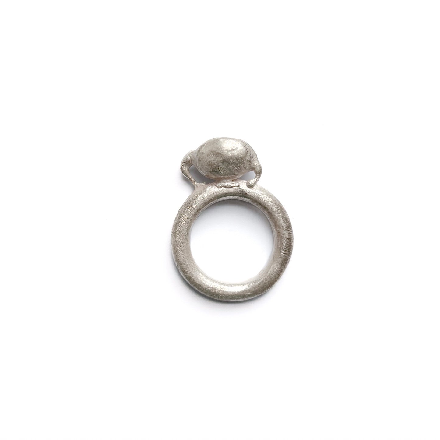 Detailaufnahme der Konstruktion: Breiter Silberdraht hält eine umgedrehte Kapsel, freigestellte Ansicht des Unikats.