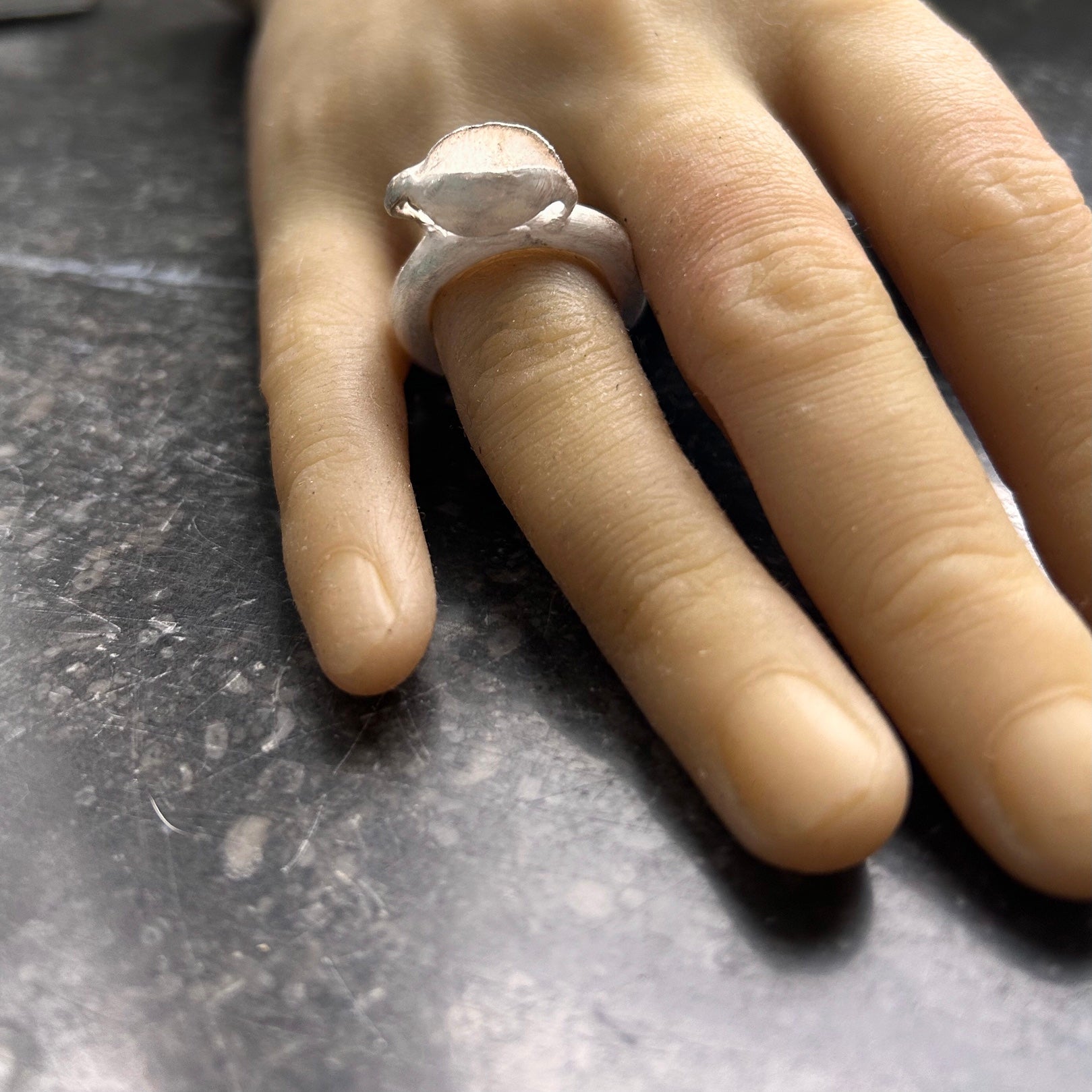 Der skulpturale Schalen-Ring an der Hand getragen, zeigt die harmonischen Proportionen und die schützende Geste des Designs.